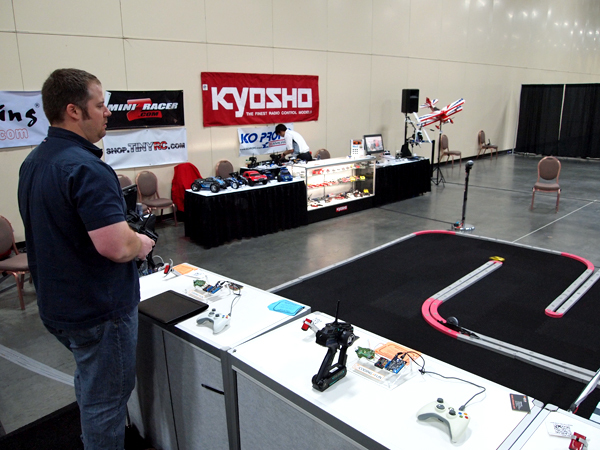 なんと！日本から「京商（KYOSHO）」が。今回ブロンズスポンサーでの協賛を行い、臨時のラジコンスペースを設けていた。会場にいた同社石原氏に伺ったところ「参加者にエンジニアが多いせいか、こういうもの（ラジコン）に対しても好意的で皆楽しんでくれました」とのこと